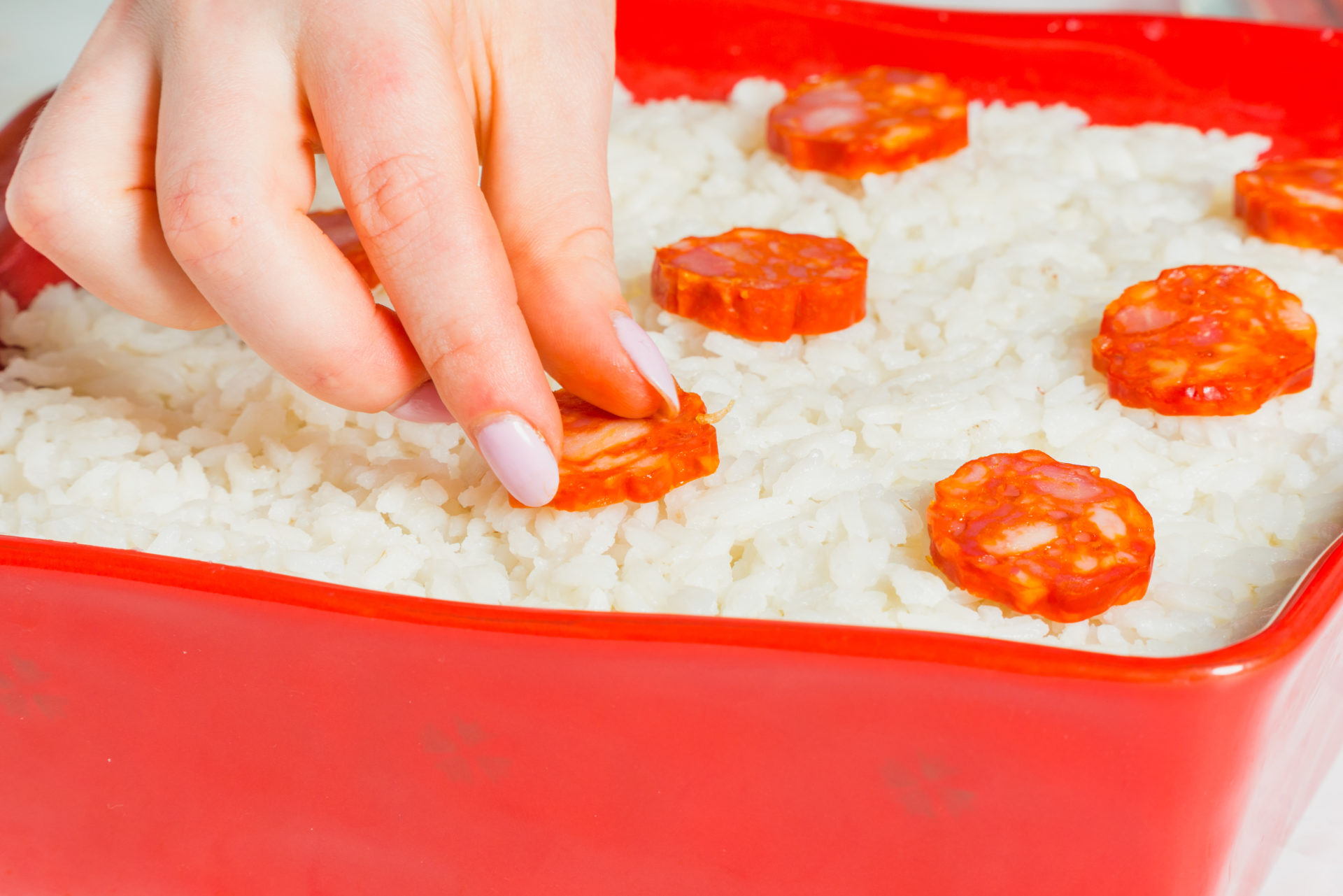 Decorar o arroz com chouriça cortada às rodelas