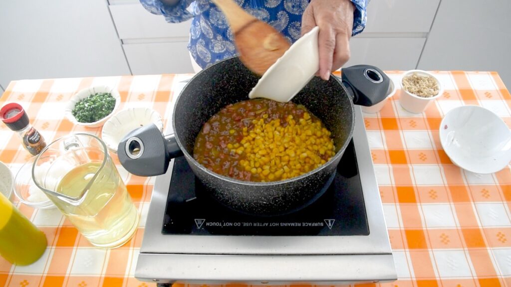 Adicione o caldo de legumes quente, o arroz e o milho cozido.
