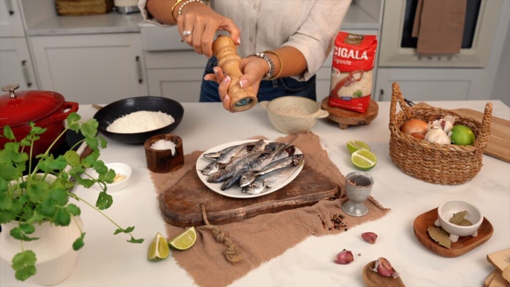 A preparação do peixe começa com o tempero: sal e pimenta a gosto, devem ser distribuídos uniformemente.