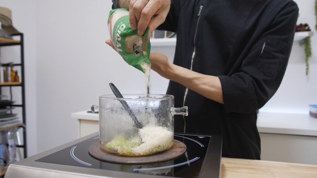 Adicione o arroz e frite ligeiramente, depois junte a polpa de tomate e o vinagre.