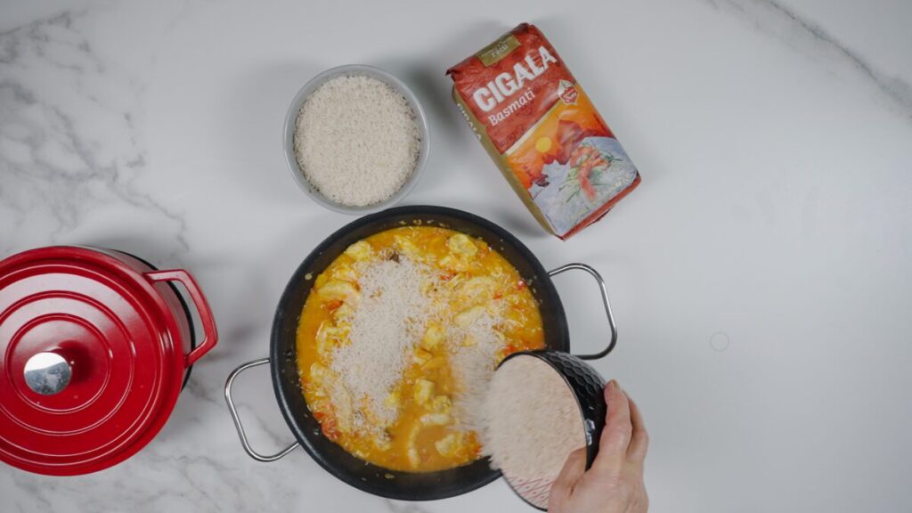 Incorpore o arroz basmati, o mexilhão, as amêijoas com e sem casca, e vá acrescentando o caldo de marisco aos poucos.