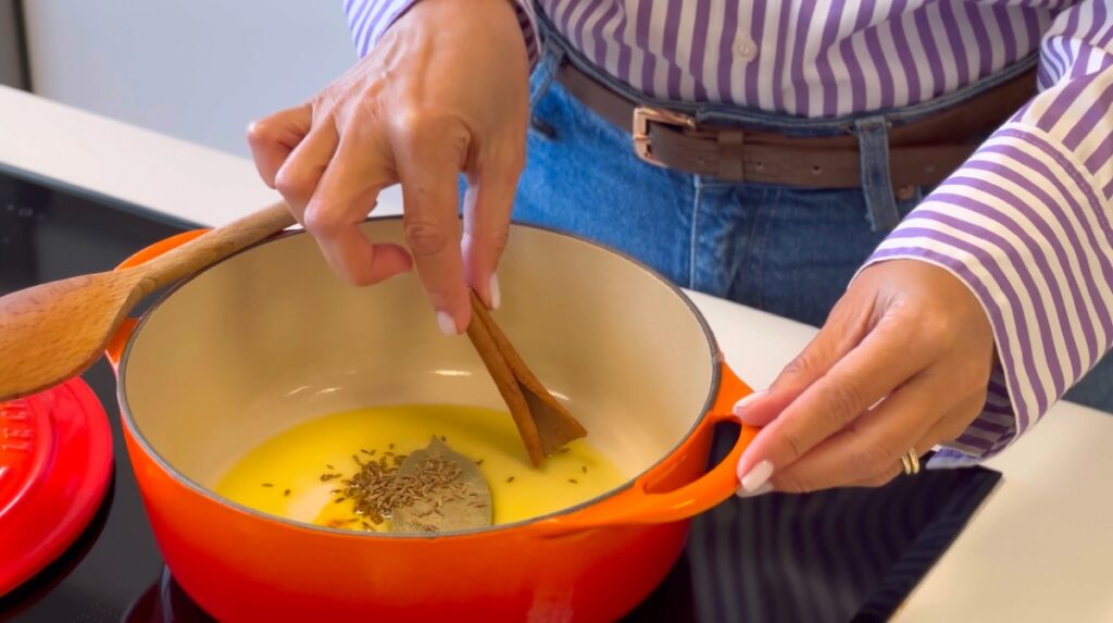 Coloque no tacho o azeite, o louro, os cominhos, o açafrão e o pau de canela.