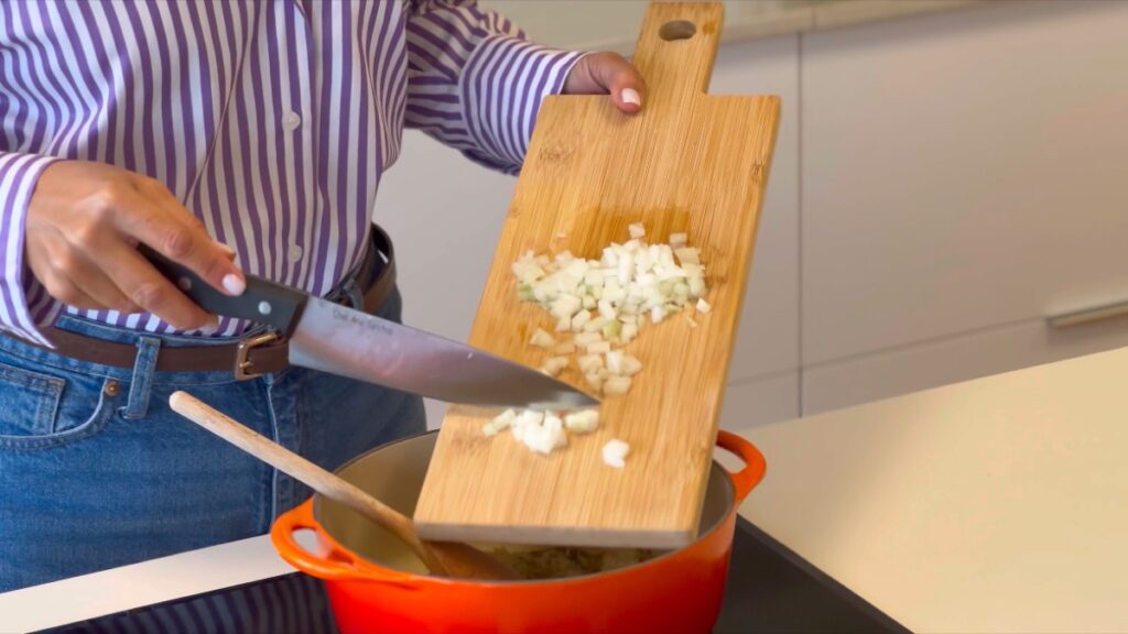 acrescente a cebola bem picada e continue a mexer por mais 1-2 minutos até que a cebola comece a ficar translúcida.
